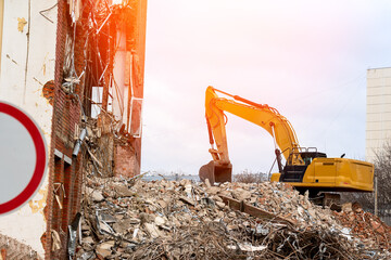 dismantling of the building, an excavator destroys an old building