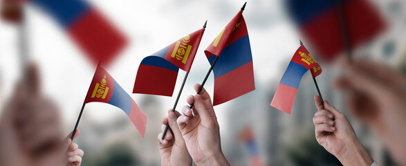 A group of people holding small flags of the Mongolia in their hands