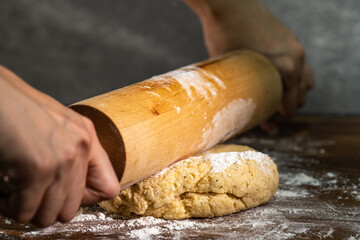 Bakery - A person prepares bread flour on a wooden table with a rolling pin in a dough