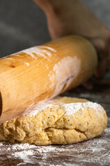 Bakery - A person prepares bread flour on a wooden table with a rolling pin in a dough