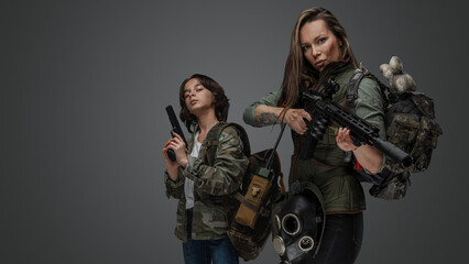 Studio shot of post apocalyptic woman and young girl against gray background.