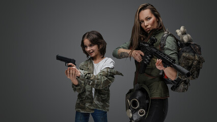 Portrait of woman and smiling young girl survivors with rifle and handgun.