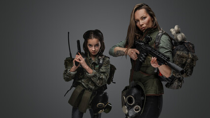 Fototapeta na wymiar Portrait of woman and young girl survivors dressed in uniform and carrying backpacks.