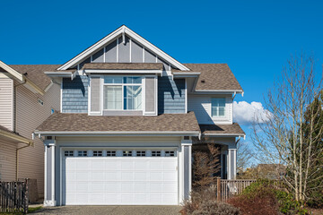 Real Estate Exterior Front House on a sunny day. Big custom made luxury house with nicely landscaped front yard