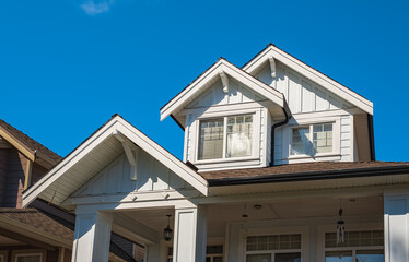 Top of a house with nice windows in the blue sky background. Beautiful Home Exterior. Real Estate Exterior Front House