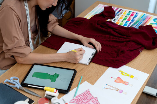 young woman designer drawing clothes using electronic  pencil