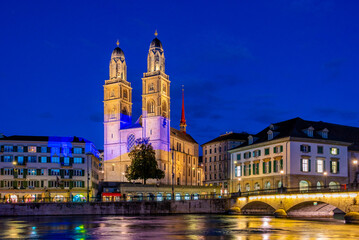 Sunset view of Limmat river with Grossmuenster cathedral in Zurich, Switzerland