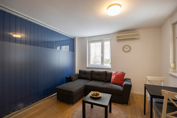 Interior of a living room with glass wall separating from bedroom