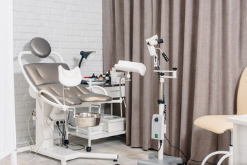 Empty gynecology office with modern colposcope and medical tools