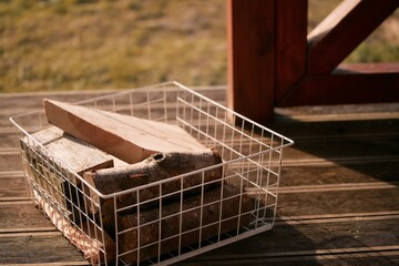 a portion of firewood in the white basket. a small pile of firewood in reserve for the winter