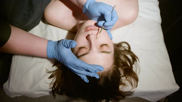 The cosmetologist makes a mechanical cleaning of the face.