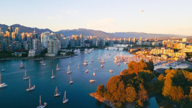 Vancouver downtown skyline aerial pullback reveal shot over marina, BC, Canada at sunset