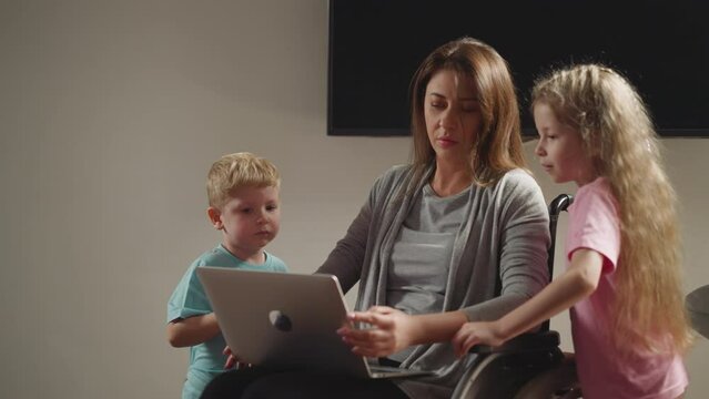 Curious preschooler and toddler bother mom working on laptop
