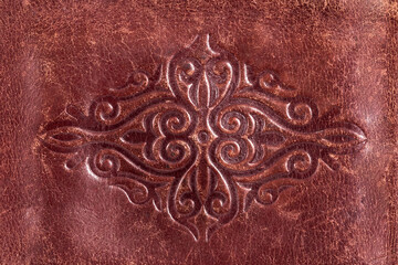 Kazakh national ornament embossed on brown leather, culture of Central Asia.
