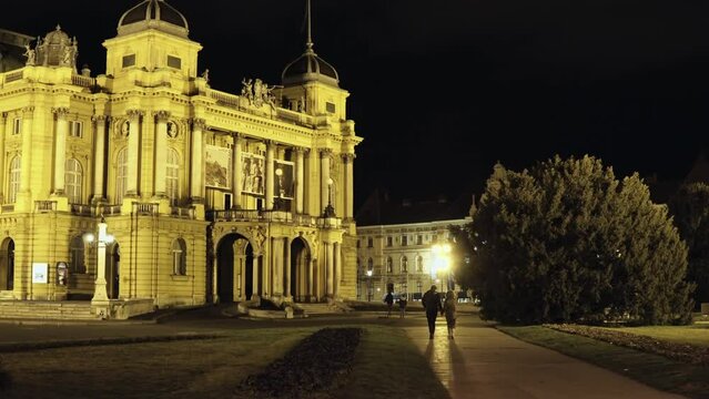 Couple walking near the Croatian National neo-baroque Theater in Zagreb that is hosting opera, drama and ballet