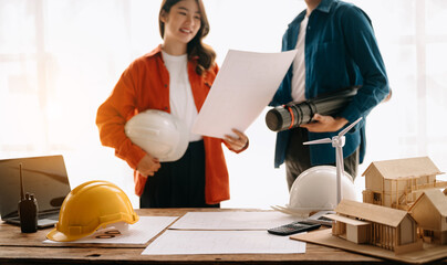 Engineer desk with object paper and tablet with blurry engineer teamwork hardworking to consults...