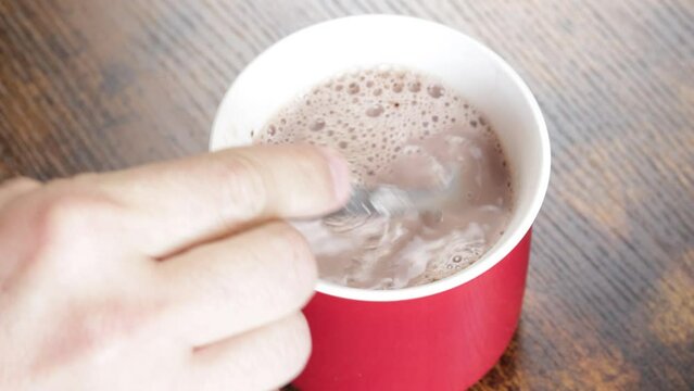 chocolat chaud dans une tasse m&eacute;lang&eacute; avec une cuill&egrave;re