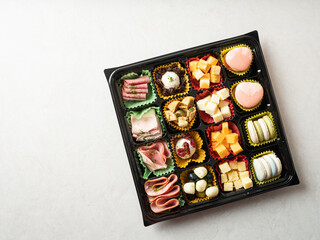 Various cheeses, raw ham and macaroons