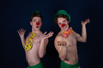 Two young attractive guys in clown costumes.