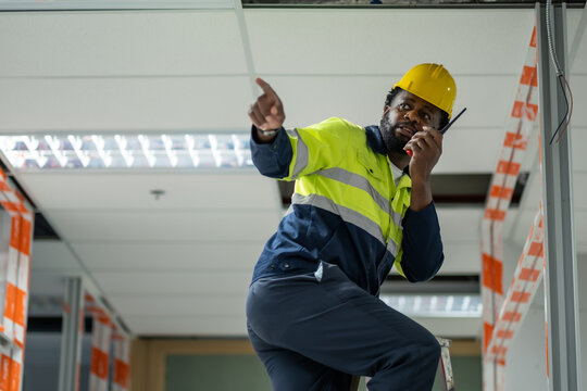 Engineer on repair laddle using walki talki call his team to help him or fix unprocess decoration system, or electric system above after his last check.