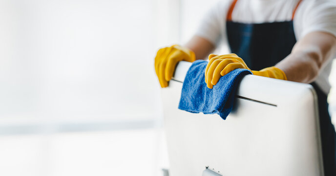 people doing cleaning are using cloths and spraying disinfectant Wipe the desk and floor in the office room..cleaning staff.cleaning maid
