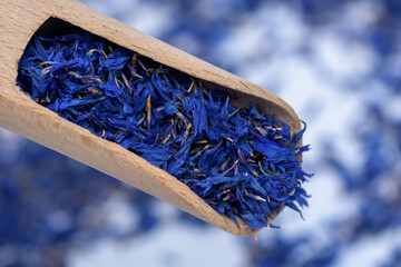 Niebieskie płatki bławatek na drewnianym nabieraku na rozmytym tle © Paweł Kacperek