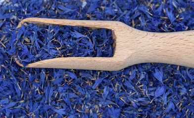 niebieskie suszone kwiaty bławatek na drewnianym nabieraku w ujęciu makro © Paweł Kacperek