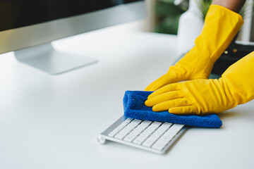 people doing cleaning are using cloths and spraying disinfectant Wipe the desk and floor in the...