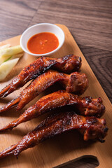 grilled bbq roasted golden honey chicken wing with spicy chilli sauce and onion on wood table asian chinese halal meat banquet snack menu for restaurant and stall