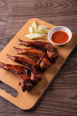 grilled bbq roasted golden honey chicken wing with spicy chilli sauce and onion on wood table asian chinese halal meat banquet snack menu for restaurant and stall