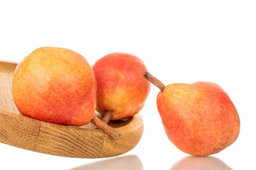 Three organic Bartlett pears on a wooden tray, macro, isolated on white background.