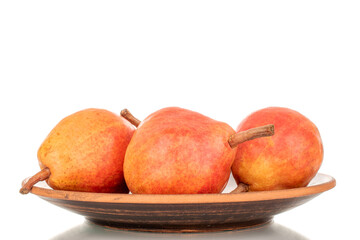 Several organic Bartlett pears on a clay dish, macro, isolated on white background.
