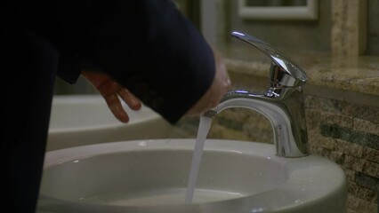 Close up of a business man washing his hands in a public restroom - Powered by Adobe
