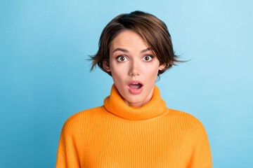 Photo portrait of attractive young woman astonished hear shocking news dressed stylish orange clothes isolated on blue color background