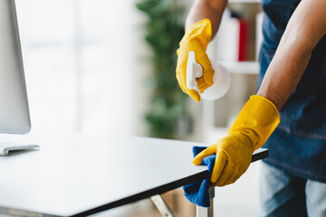 people doing cleaning are using cloths and spraying disinfectant Wipe the desk and floor in the office room..cleaning staff.cleaning maid