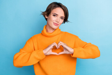 Photo portrait of pretty young girl showing fingers heart love gesture feedback wear trendy orange...