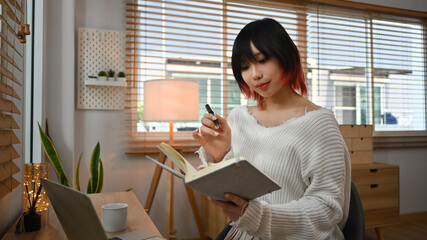 Young start up online seller owner using laptop for checking customer orders from email or website at home office