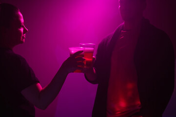 Woman and man drinking beer in a nightclub.
