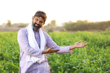  Happy rural Indian a farmer pointing at his right side while looking at the camera.