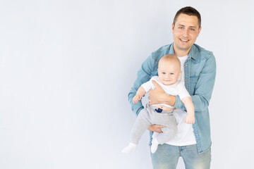a father with a small child son on a white isolated empty background in a photo studio playing, hugging. Happy fatherhood or family
