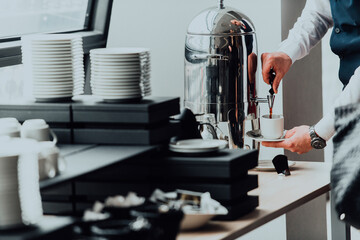 The waiter preparing coffee for hotel guests. Close up photo of service in modern hotels