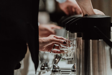 The waiter preparing coffee for hotel guests. Close up photo of service in modern hotels