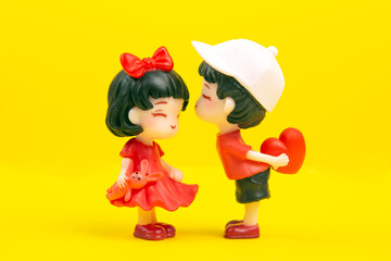 miniature people. figures for the game. romantic couple of young people. A boy lovingly gives his heart to a cute girl