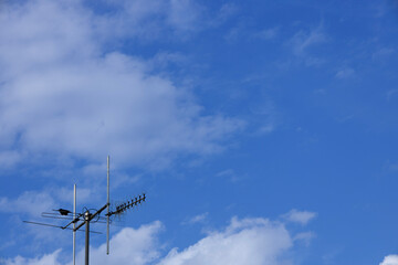 Obraz premium Terrestrial television antenna with a bird against blue sky.