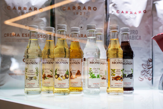 Showcase of a coffee shop with selective focus on the row of syrups bottles Monin. Monin is, a French company, one of the largest syrup producers in the world. Minsk, Belarus, 2023