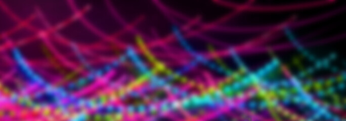 Blurred abstract background. Drawing with light, garlands with multi-colored LED bulbs, shooting while moving at a slow shutter speed.