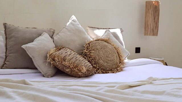 Lots of throw pillows on a bed in Bali boho villa bedroom, close-up