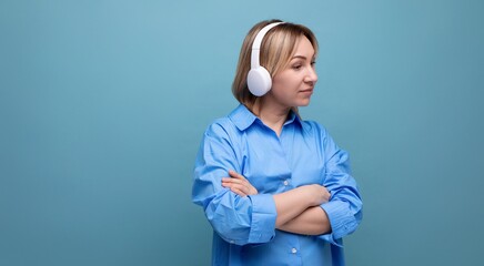widescreen photo of a pensive european girl in a casual shirt listening to music in big white...