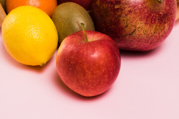 Fruits in a reusable bag on a pink background, lemon and apple close-up. Earth day and zero waste concept.