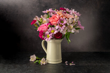 Beautiful fresh flowers. Pink bouquet of flowers in vase, on black background.